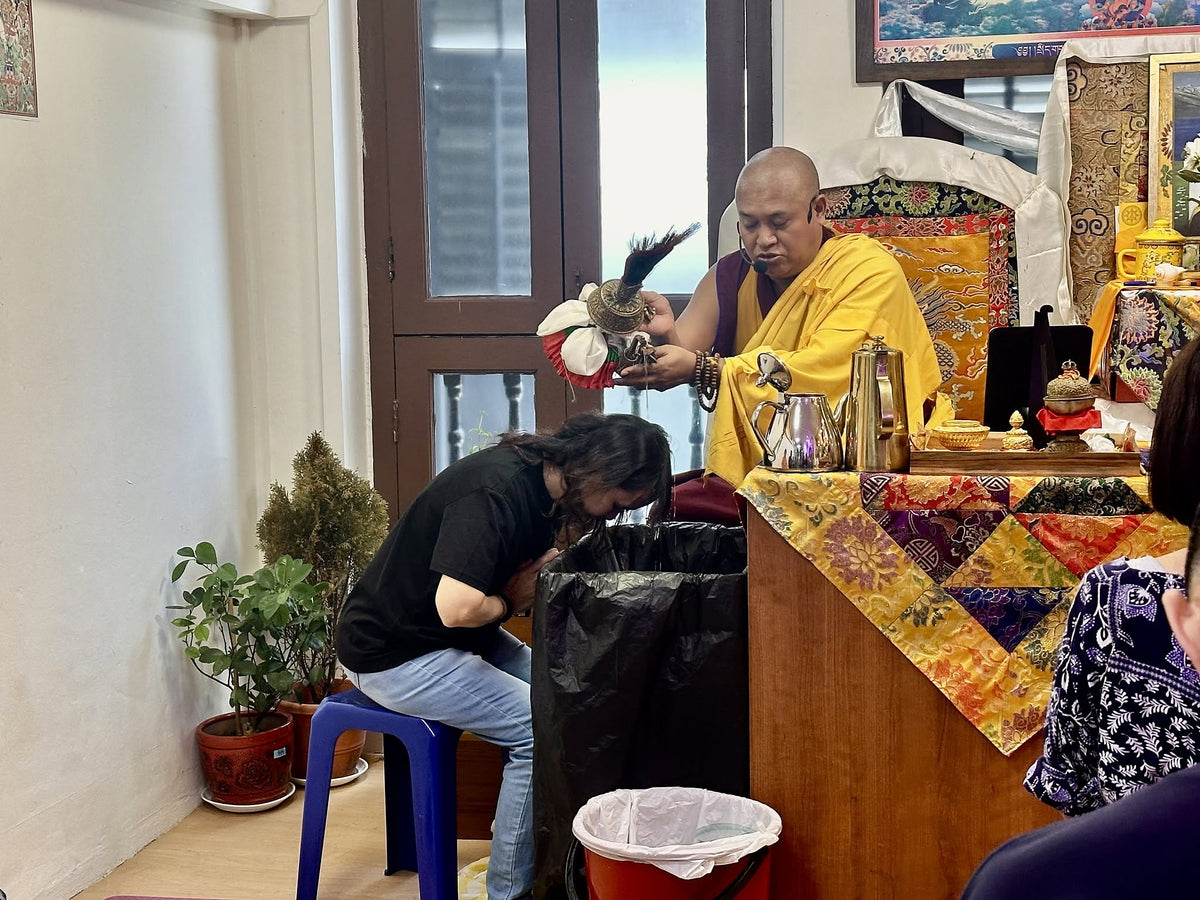A devotee receives the water blessing from Rinpoche