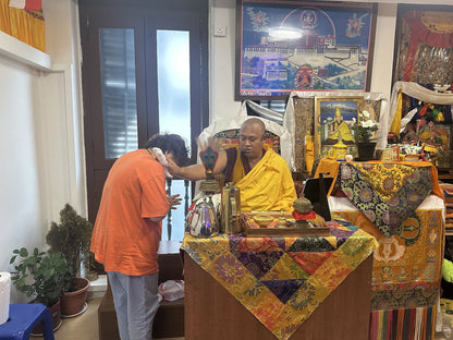 Rinpoche giving the vajra blessing to a devotee